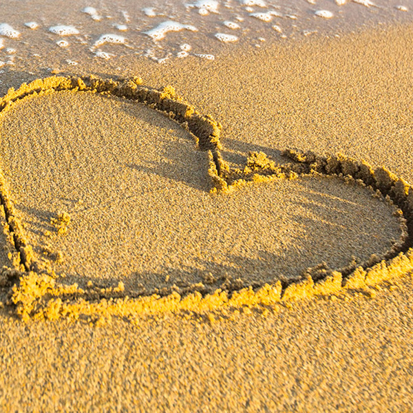 image of beach with heart drawn in sand